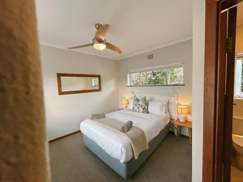a bedroom with a bed and a ceiling fan at Leisure Isle Loft Apartment in Knysna