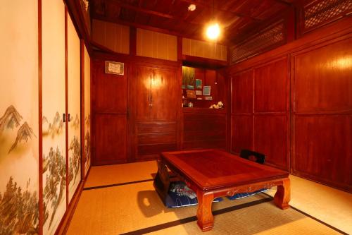 Holzzimmer mit einem Holztisch. in der Unterkunft ごーやー荘 in Okinawa