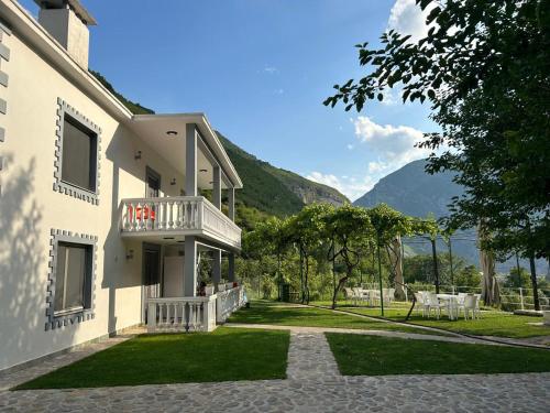 a white house with a balcony and a lawn at Bujtina Lecaj in Selcë
