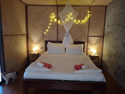 a bedroom with a large bed with lights on it at Tree House Bungalows Koh Tao in Koh Tao