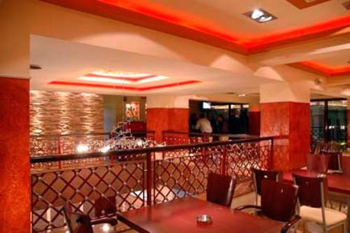 un restaurante con un bar con mesas y sillas en Hotel Olympion, en Katerini