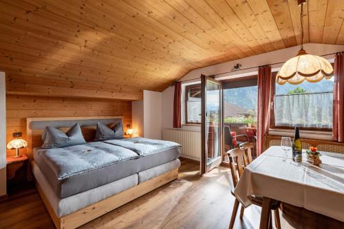 a bedroom with a bed and a dining room with a table at Appartementhaus Ederegger in Ebbs