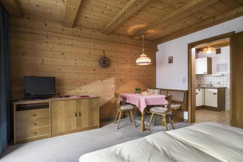 a bedroom with a table and a tv in a room at Appartementhaus Ederegger in Ebbs