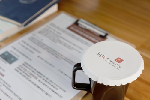 a coffee cup sitting on top of a table at With Stay Jeju Hotel in Jeju
