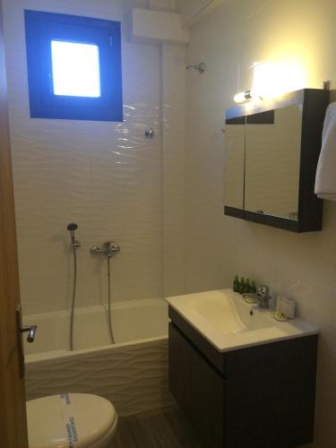 a bathroom with a toilet and a sink and a shower at Catherine Villas in Maronia
