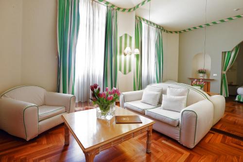 a living room with two couches and a coffee table at Lolli Palace Hotel in Sanremo