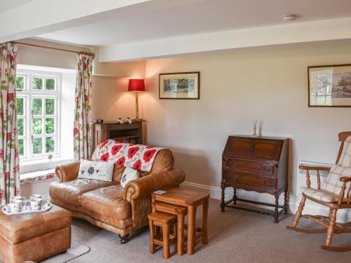 a living room with a couch and a chair at 1 The Old Corn Mill in West Burton