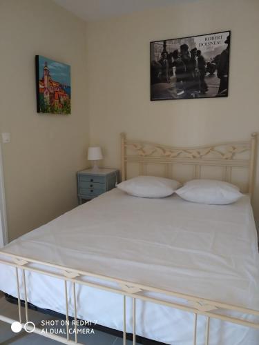 - un lit blanc avec deux oreillers dans une chambre dans l'établissement Beau T2 150 m de la plage à Bormes les mimosas, à Bormes-les-Mimosas
