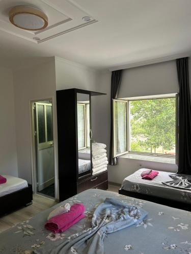 a bedroom with two beds and a large window at Bujtina Lecaj in Selcë
