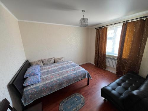 a bedroom with a bed and a couch at Домик у моря in Ömirzaq