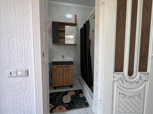 a small bathroom with a sink and a mirror at Домик у моря in Ömirzaq