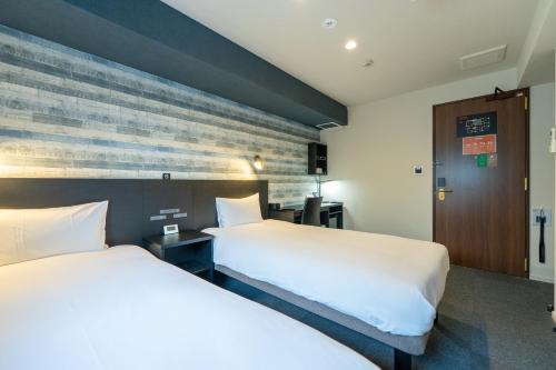 a hotel room with two beds and a wall at HOTEL TABARD TOKYO in Tokyo
