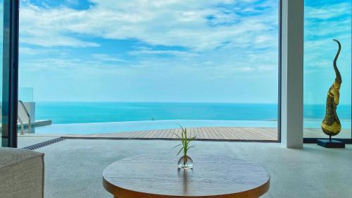 a room with a table and a view of the ocean at Anzhu Seamate Villa Samui in Amphoe Koh Samui