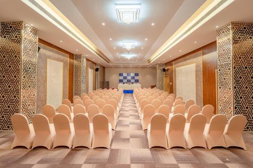 an empty conference room with chairs and a stage at Pravasa Hotel Vijayapura in Bijāpur