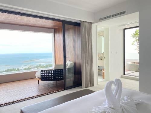 a bedroom with a view of the ocean at Anzhu Seamate Villa Samui in Amphoe Koh Samui
