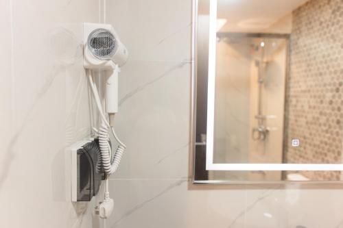 a bathroom with a blow dryer and a mirror at Comfy Quite Private Room with Private Balcony - Hulhumale in Hulhumale