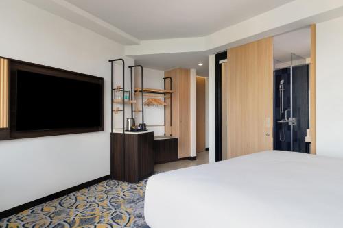 a hotel room with a bed and a flat screen tv at Hilton Garden Inn Mumbai International Airport in Mumbai