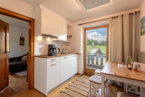 a kitchen with a table and a large window at Oberachenhof in Ellmau