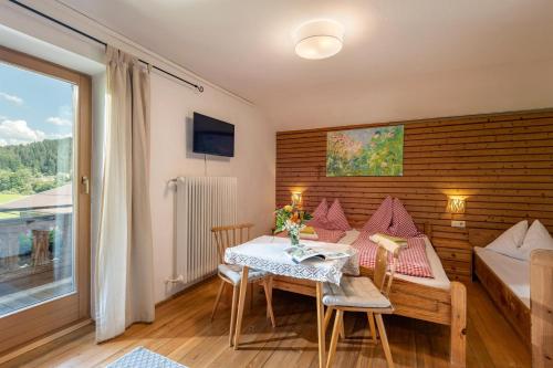 a small room with a table and chairs and a bed at Oberachenhof in Ellmau