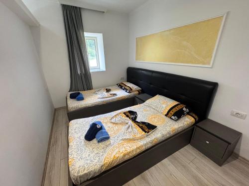 two beds in a small room with at Bujtina Lecaj in Selcë