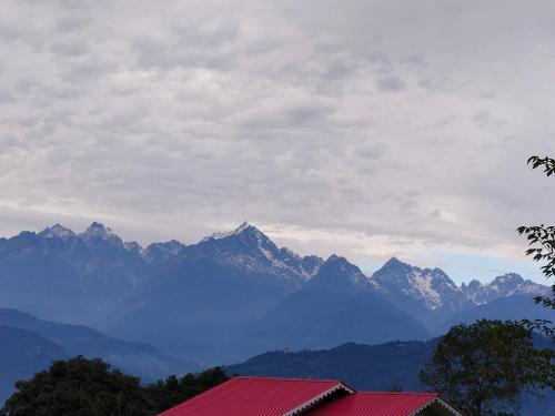 a view of a mountain range with a red roof at Tenzing's homestay in Sosing