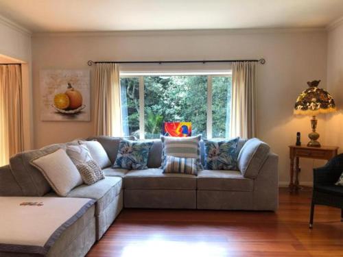 a living room with a couch and a window at NZ County Holiday Home in Kamo