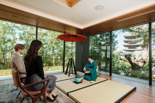 a family sitting in a living room with large windows at The Hotel Seiryu Kyoto Kiyomizu - a member of the Leading Hotels of the World- in Kyoto