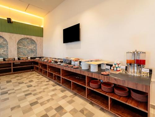 a restaurant with a counter with plates on it at Pravasa Hotel Vijayapura in Bijāpur