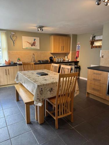 a kitchen with a table and two chairs and a table and a kitchen at The Old Shop at Savile House - Sherwood Forest in Ollerton