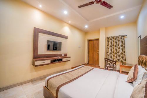 a bedroom with a bed and a tv on the wall at HOTEL AUGUSTO in Varanasi