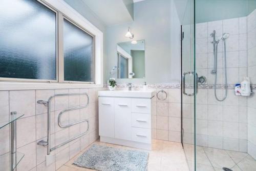 a bathroom with a glass shower and a sink at NZ County Holiday Home in Kamo