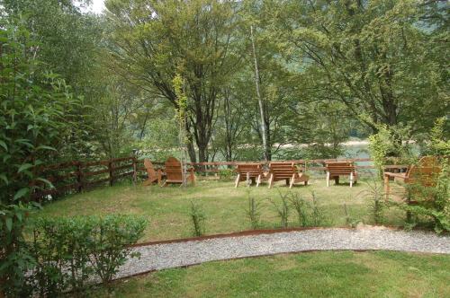 a group of wooden benches in a park at Casa Lacului in Malaia