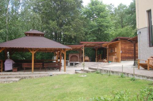 a wooden pavilion with a picnic table and benches at Casa Lacului in Malaia