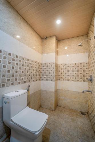 a bathroom with a toilet and a shower at HOTEL AUGUSTO in Varanasi