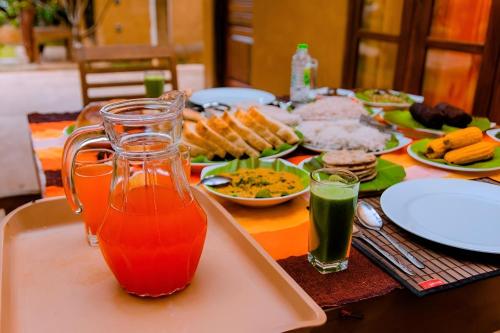 a table with plates of food and a tray of juice at Bundala Bird View in Hambantota
