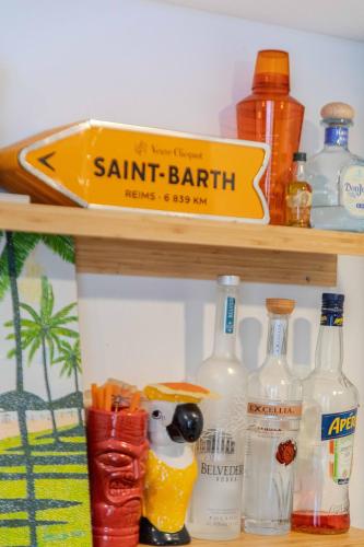 a shelf with drinks and bottles on it at St Jean studio steps away from the beach in Saint-Jean