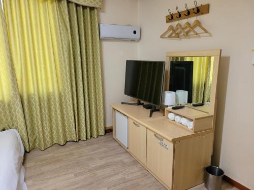 a hotel room with a television and a mirror at The Red House in Sokcho
