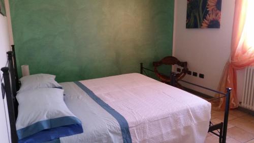 a bedroom with a bed and a green wall at Il borgo in Tavullia