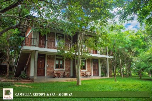 a red brick house with trees in front of it at Camellia Resort And Spa Sigiriya - Sri Lanka in Avudangawa