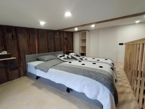 a bedroom with a large bed with wooden walls at Courtyard Condo Sunset in Liepāja