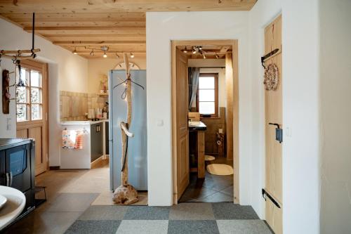 a living room with a refrigerator and a kitchen at Ferienwohnung Allgäutraum mit Bergblick in Oy-Mittelberg