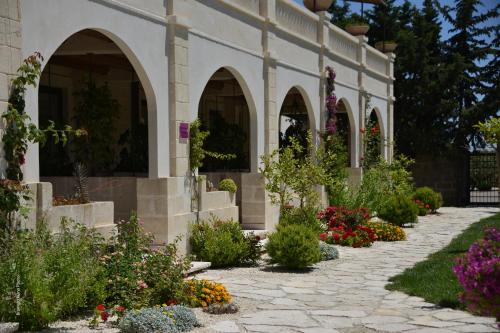 a garden with flowers in front of a building at Le Scuderie - Castello Monaci in Salice Salentino