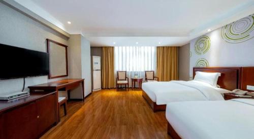 a hotel room with two beds and a flat screen tv at GreenTree Inn Nanning Langdong Hotel in Nanning