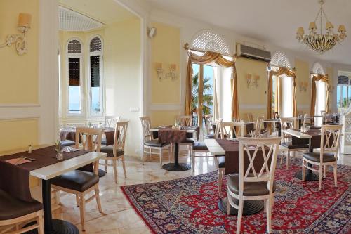 restauracja ze stołami i krzesłami oraz żyrandolem w obiekcie Lolli Palace Hotel w San Remo
