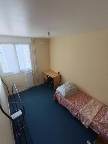 a bedroom with a bed and a desk in it at Beautiful private room in apartment in Saint-Pierre-des-Corps