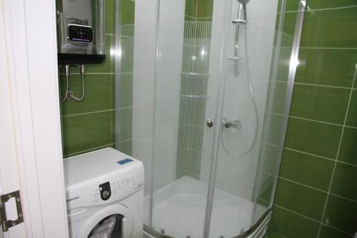 y baño con ducha y lavadora. en Apartment at Sunset Kvariati, en Kvariati