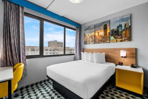 a hotel room with a bed and a large window at Days Inn by Wyndham New York Chinatown in New York