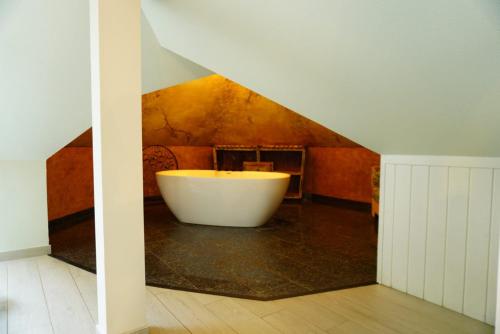 a bathroom with a tub in the middle of a room at Willa Antyki24 nad Białym Jeziorem - Las in Sztum