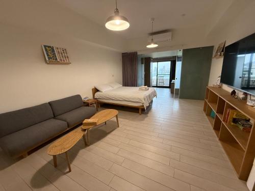 a living room with a couch and a bed at Sunrise Hot Spring House in Toucheng