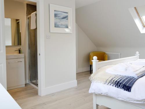 a white bedroom with a bed and a bathroom at Darroch View in Ballater